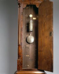 Interior of the clock showing weights, pendulum, and day labels.